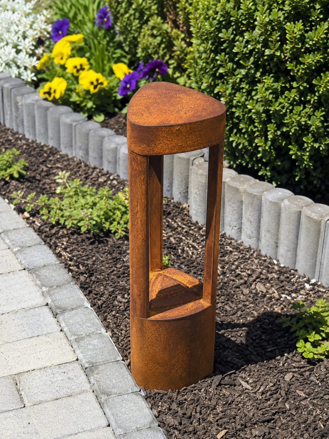Moderne Pollerleuchte mit echter Rostbeschichtung im Garten